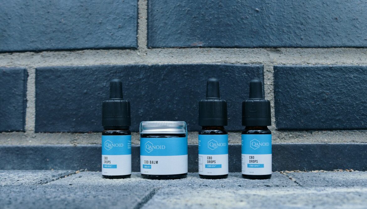 a group of three bottles of cbd next to a brick wall