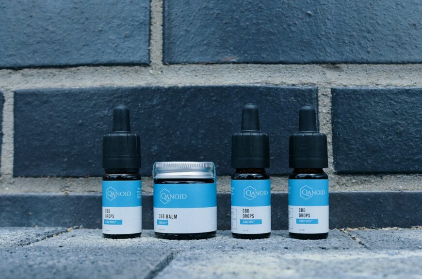 a group of three bottles of cbd next to a brick wall